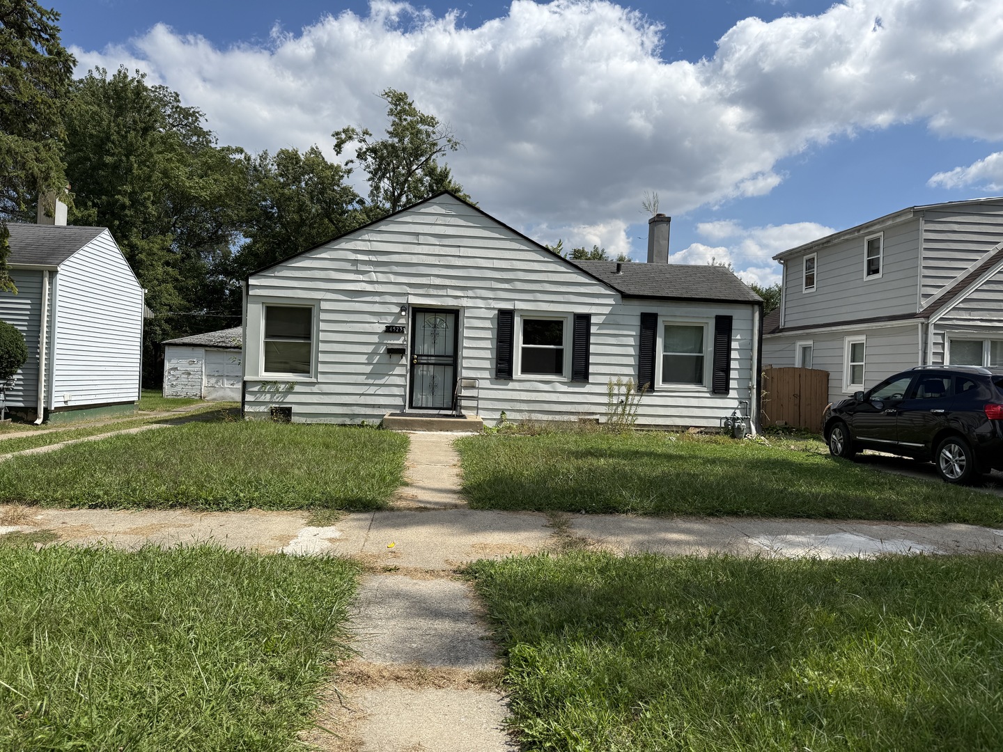 a front view of a house with a yard and potted plants