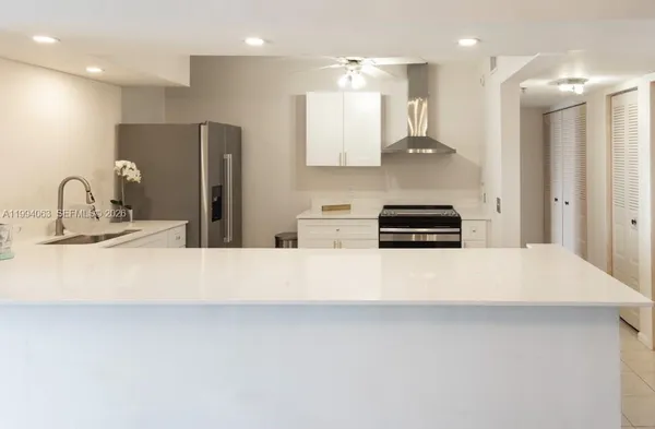 a kitchen with stainless steel appliances a refrigerator and a stove top oven