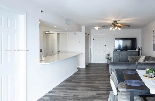 a large white kitchen with a large island oven a sink stainless steel appliances and cabinets