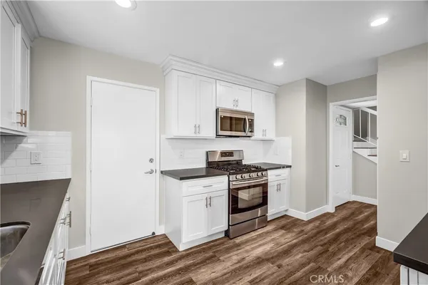 a kitchen with stainless steel appliances granite countertop white cabinets granite counter tops and a stove