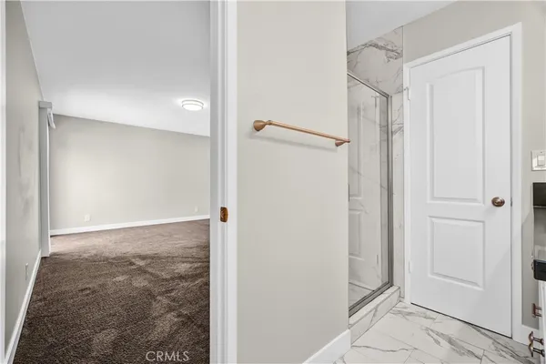 a spacious bedroom with a bed a lamp and a large window