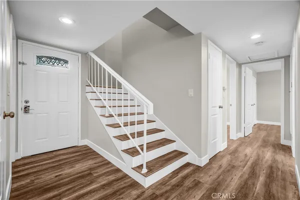 a view of a hallway with wooden floor and white walls