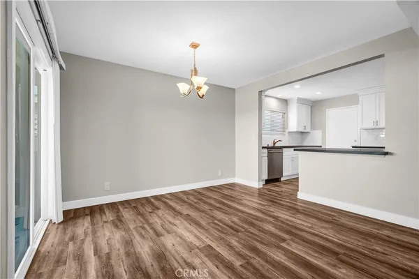 a view of empty room with wooden floor and windows
