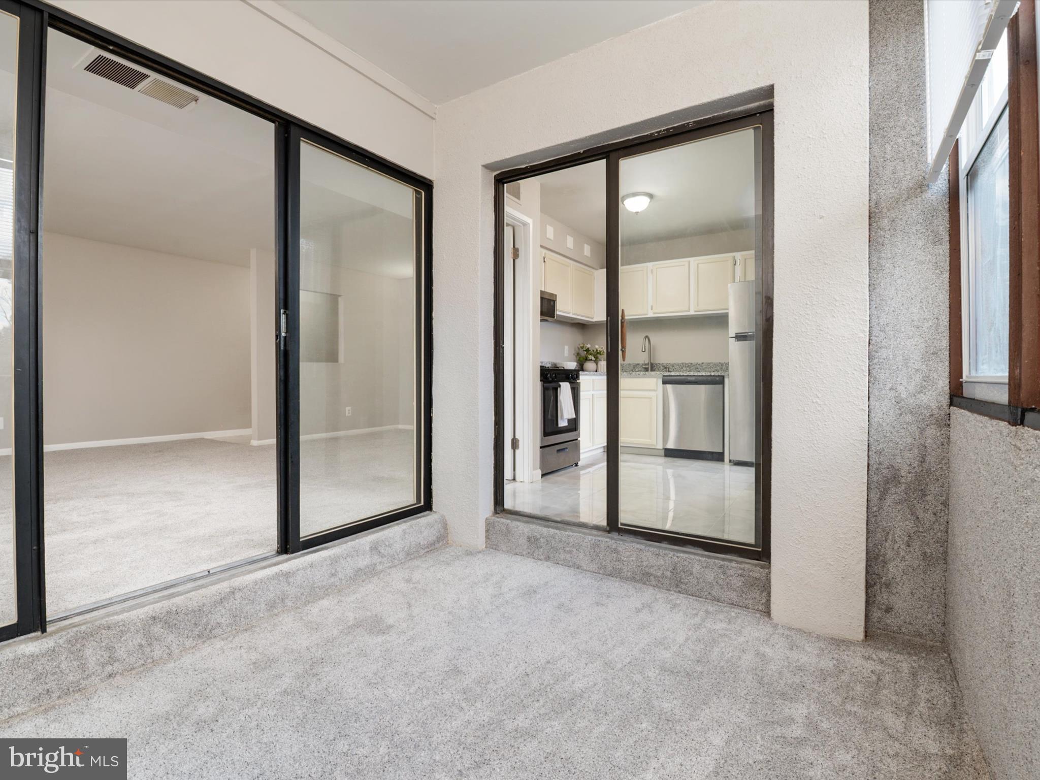 9639 White Acre Road, Unit B1 Columbia, MD 21045 - Photo 11 of 23 an empty room with sliding glass door and shower