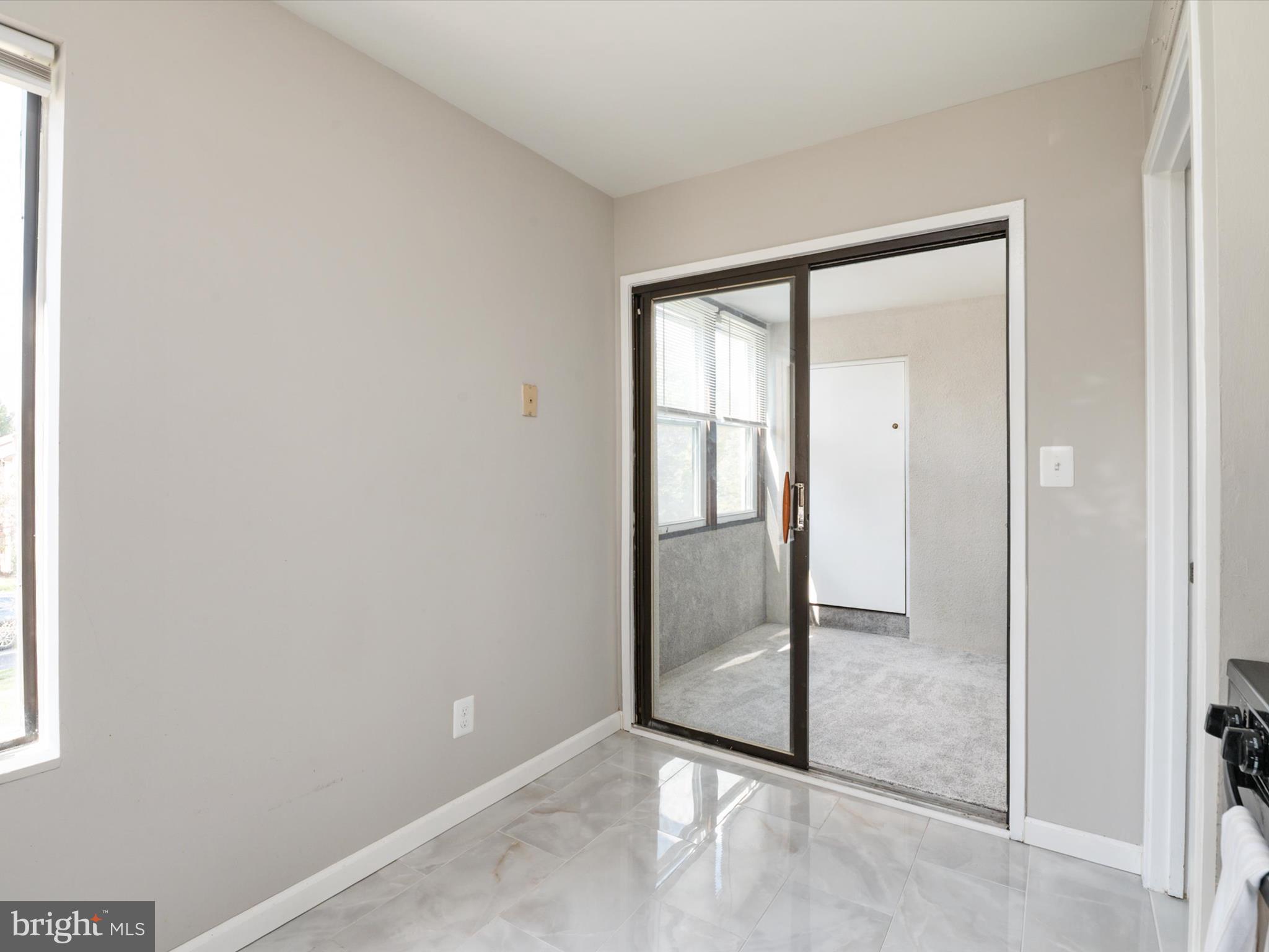 9639 White Acre Road, Unit B1 Columbia, MD 21045 - Photo 14 of 23 an empty room with sliding door and balcony