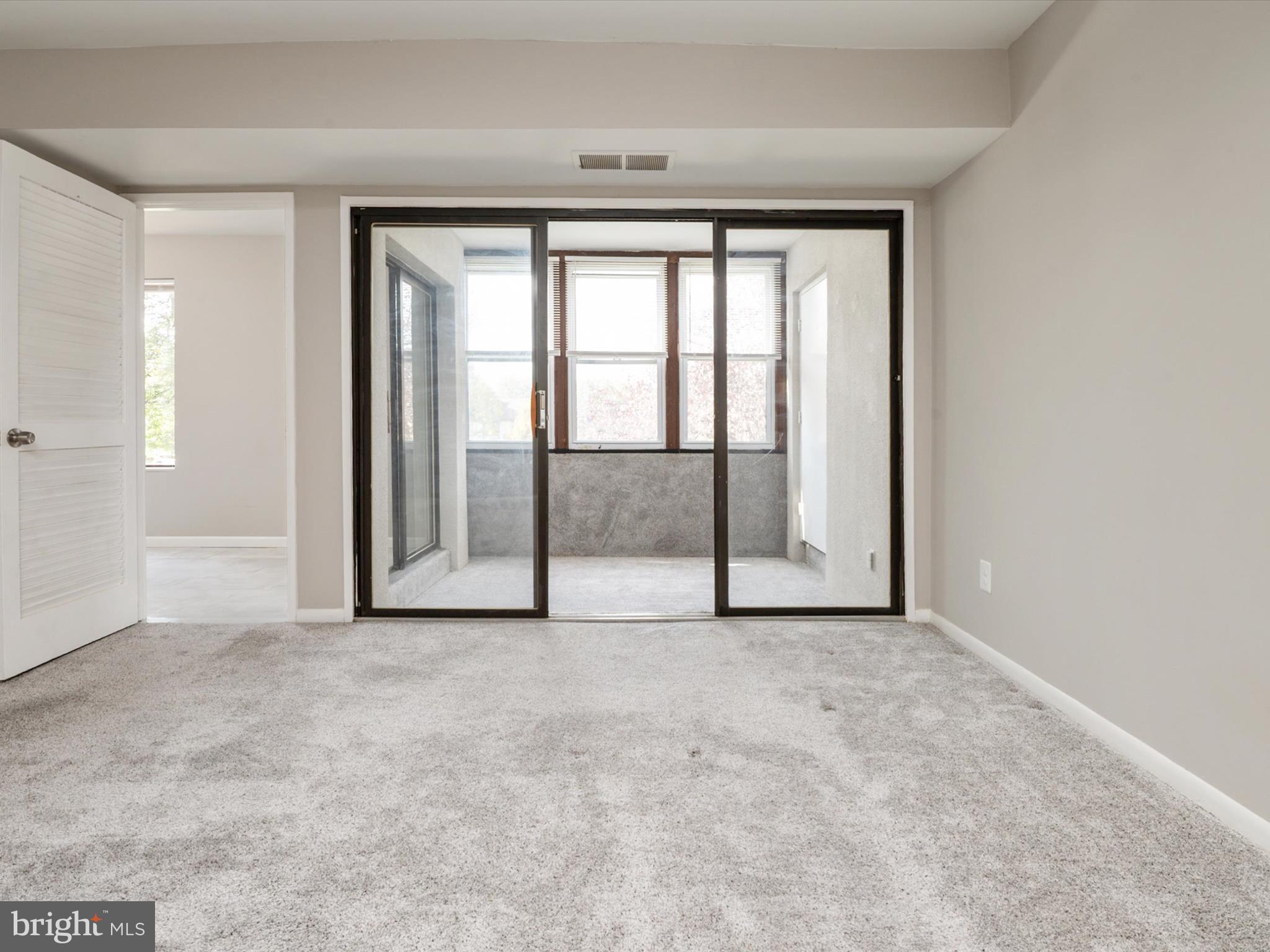 9639 White Acre Road, Unit B1 Columbia, MD 21045 - Photo 9 of 23 an empty room with sliding glass door