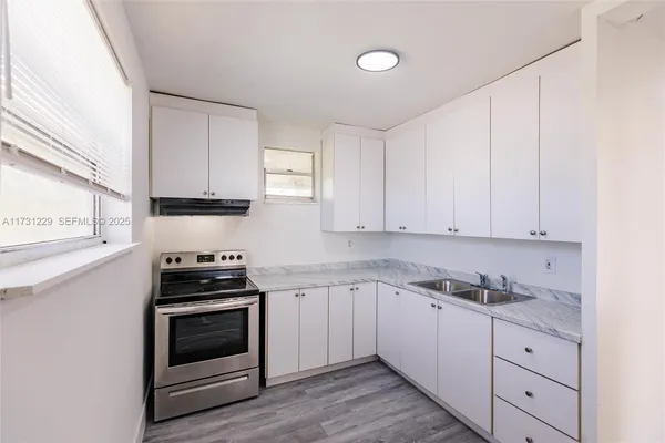 a kitchen with granite countertop white cabinets and stainless steel appliances