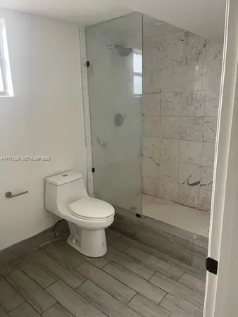 a bathroom with a toilet and a shower