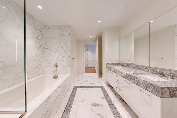 a spacious bathroom with a tub sink and mirror