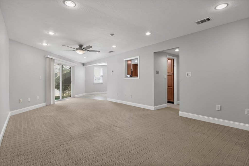 33 Christopher Drive, Unit A Stoughton, MA 02072 - Photo 3 of 23 an empty room with windows and chandelier fan