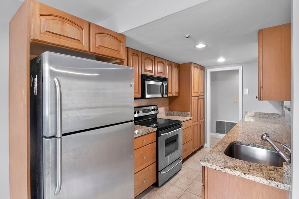 33 Christopher Drive, Unit A Stoughton, MA 02072 - Photo 4 of 23 a kitchen with stainless steel appliances granite countertop a refrigerator a stove and a sink