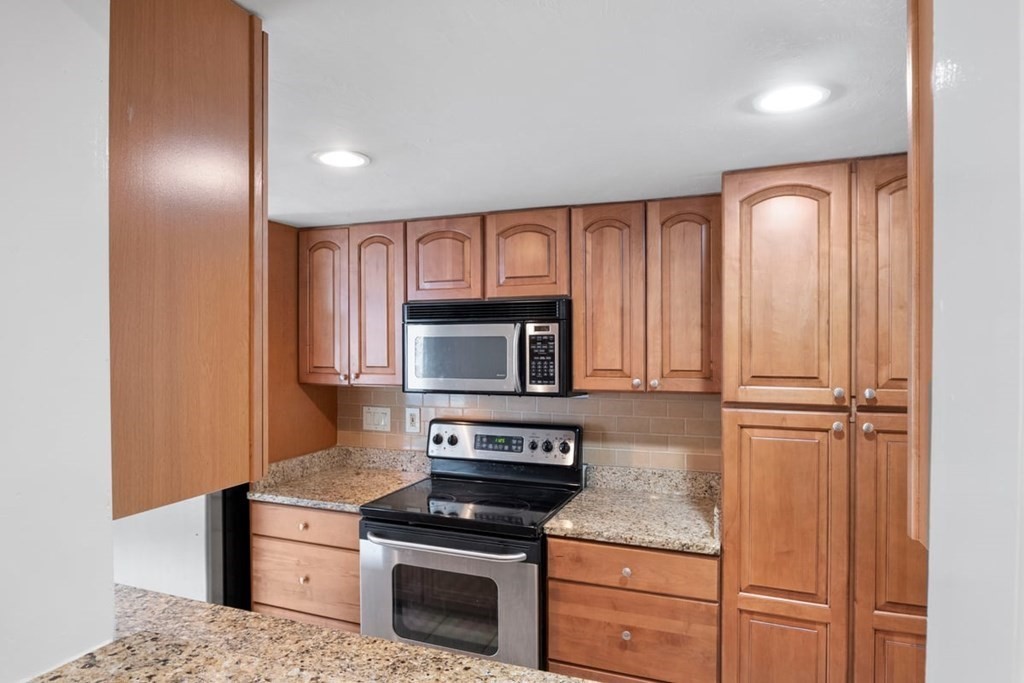 33 Christopher Drive, Unit A Stoughton, MA 02072 - Photo 6 of 23 a kitchen with granite countertop cabinets stainless steel appliances and a counter space