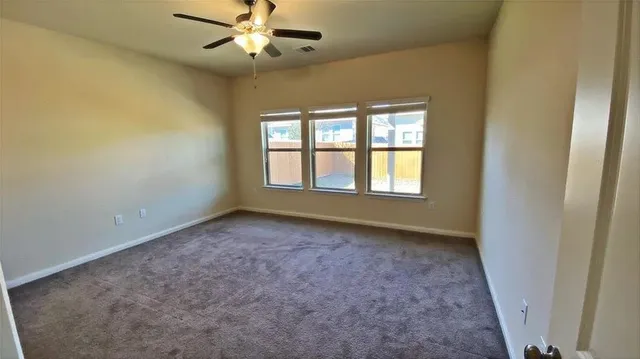 an empty room with a window and a fan