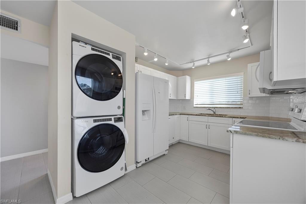 4372 27th Court Southwest, Unit 301 Naples, FL 34116 - Photo 12 of 37 a view of a kitchen with sink washer and dryer