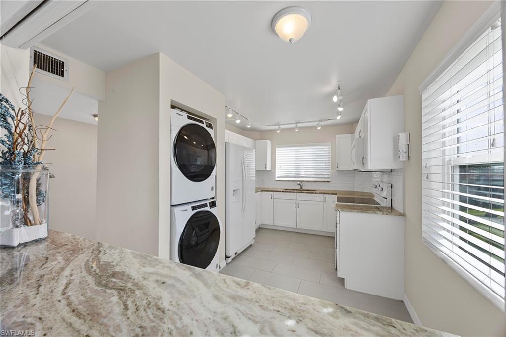 4372 27th Court Southwest, Unit 301 Naples, FL 34116 - Photo 13 of 37 a kitchen with a washer and dryer
