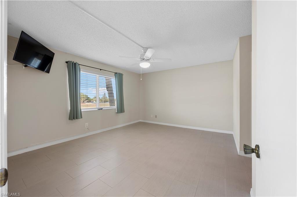 4372 27th Court Southwest, Unit 301 Naples, FL 34116 - Photo 21 of 37 an empty room with windows and fireplace
