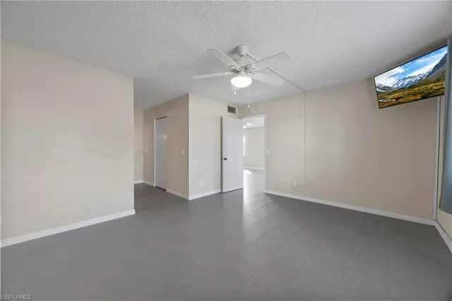 an empty room with a ceiling fan and a window