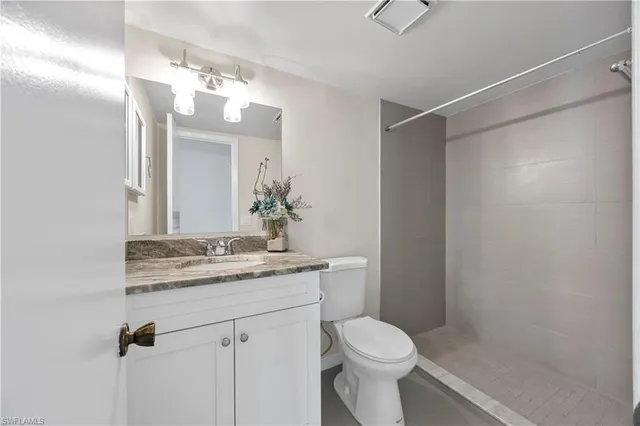 a bathroom with a granite countertop sink a toilet and a mirror