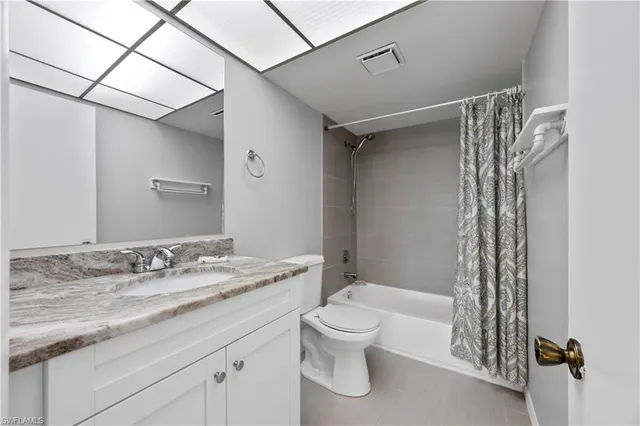 a bathroom with a granite countertop sink a toilet and shower