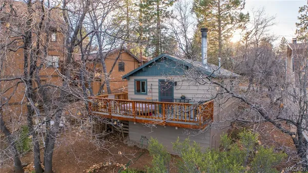 a view of house with yard and trees in the background