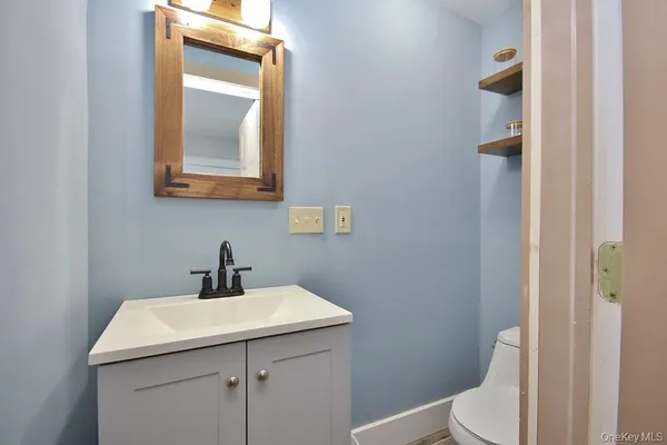a bathroom with a toilet sink and mirror