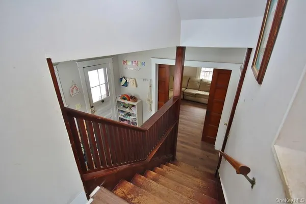 a view of a hallway with wooden floor and stairs
