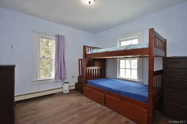 a bedroom with furniture wooden floor and a window