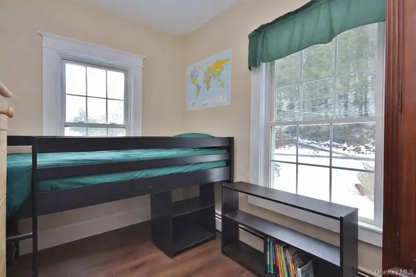 a living room with a bed furniture and next to a window