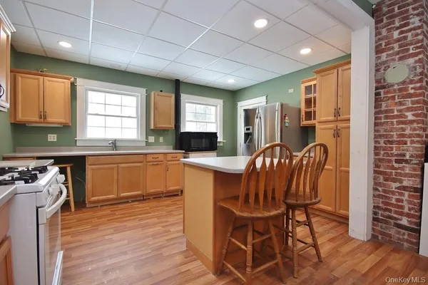 a kitchen with granite countertop a stove a sink a dining table and chairs