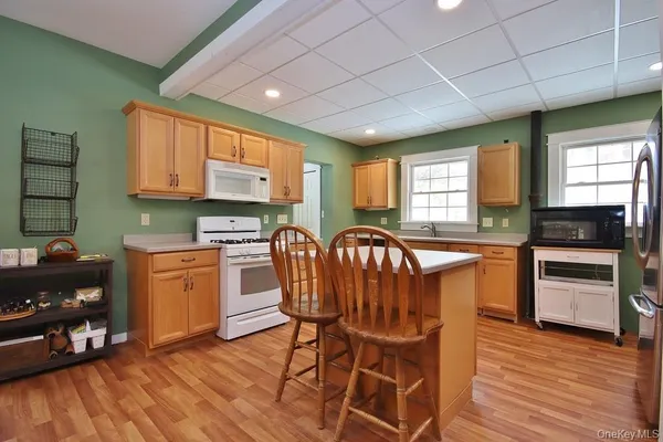 a kitchen with stainless steel appliances granite countertop a stove a sink dishwasher and a refrigerator with wooden floor