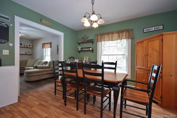 a dining room with furniture a chandelier and wooden floor