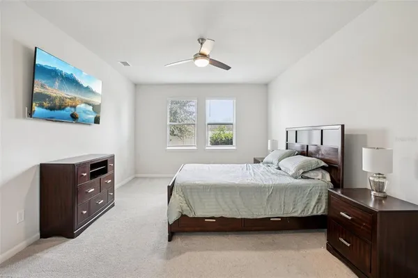 a bedroom with a bed and a dresser next to a window