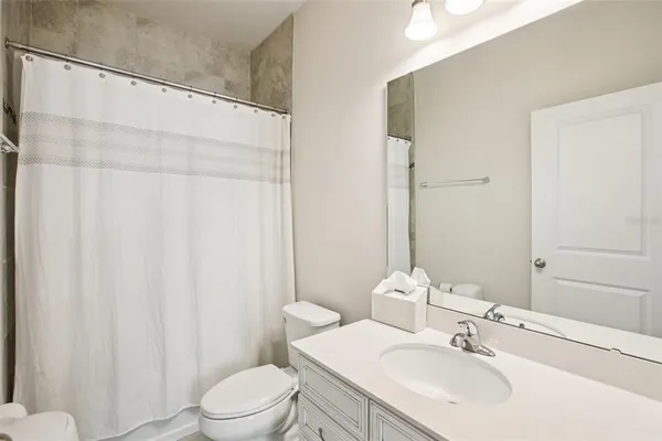 a bathroom with a sink a toilet and shower curtain