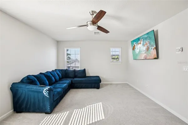 a living room with furniture and a ceiling fan