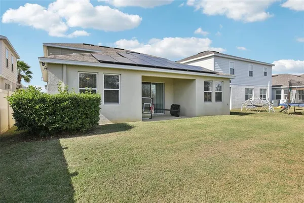 a view of a white house with a yard and plants