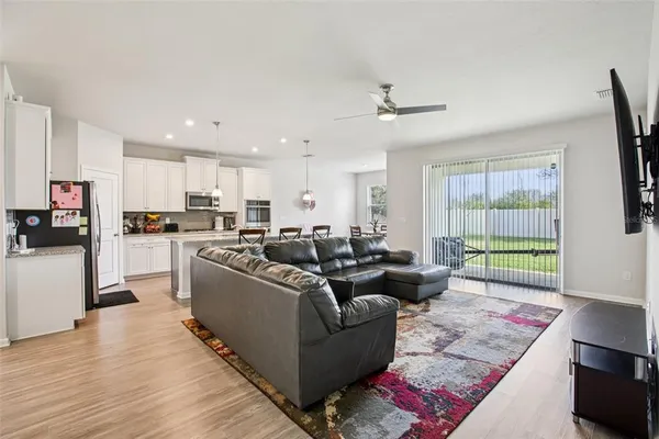 a living room with furniture and a open kitchen view