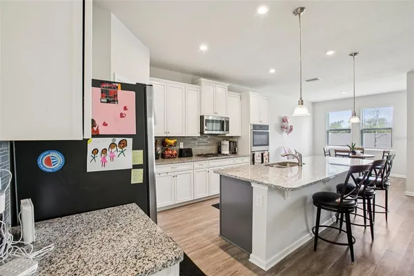 a kitchen with kitchen island appliances and cabinets