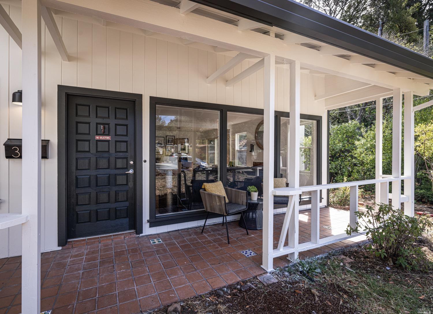 a view of a porch with chairs and floor to ceiling window