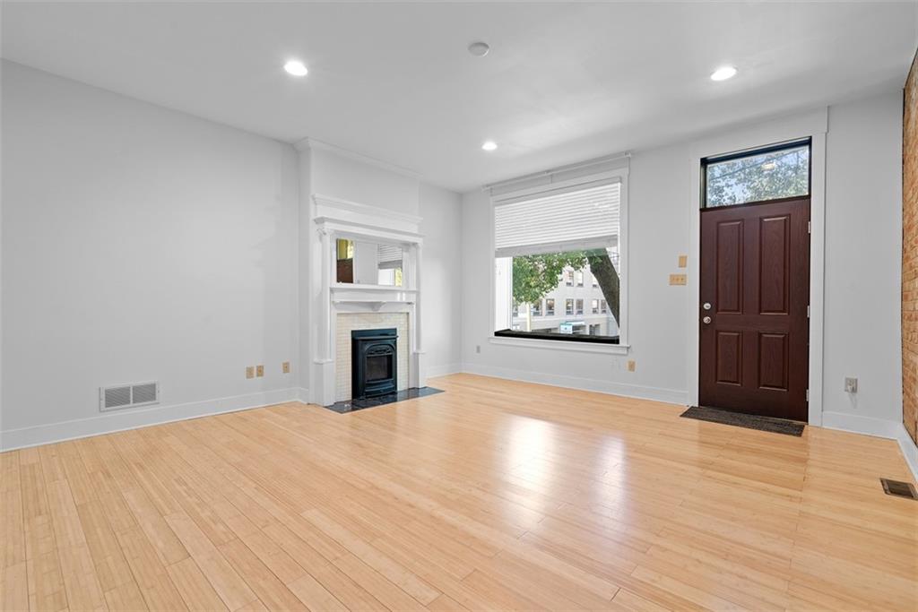 1402 James Street Pittsburgh, PA 15212 - Photo 8 of 30 an empty room with windows fireplace and wooden floor