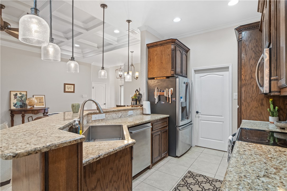 6934 Wooldridge Road, Unit K Corpus Christi, TX 78414 - Photo 8 of 20 a kitchen with a sink a counter and chairs