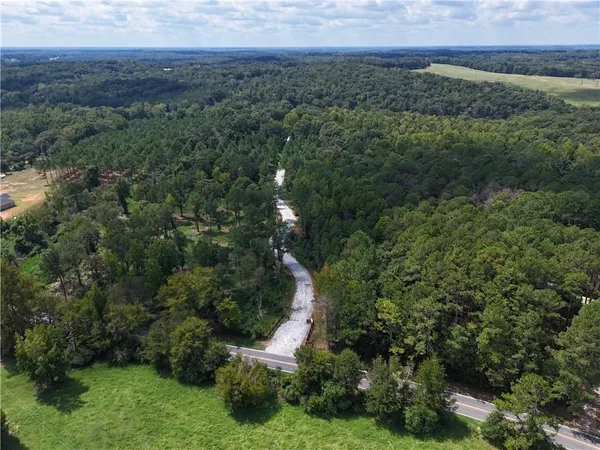 an aerial view of a houses with a yard and trees