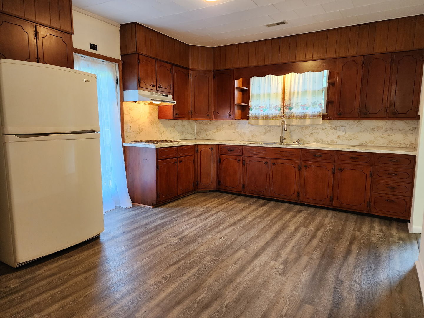 1300 West Madison Street Herrin, IL 62948 - Photo 4 of 14 a kitchen with granite countertop wooden floors a stove a sink and a refrigerator