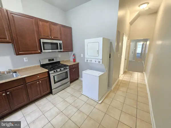a kitchen with stainless steel appliances a sink a stove a microwave a sink a refrigerator and cabinets