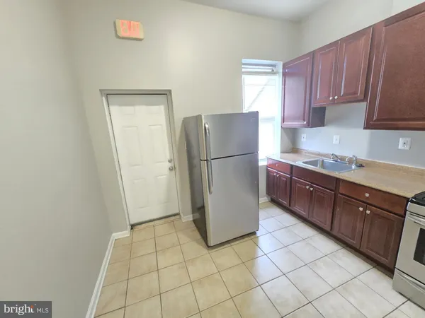 a kitchen with a refrigerator a stove top oven and cabinets