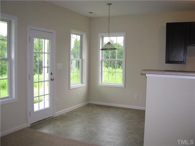6328 Slopeside Court Raleigh, NC 27610 - Photo 8 of 18 Open Breakfast Room to Living Room and Kitchen plus access to Covered Rear Porch overlooking wooded area