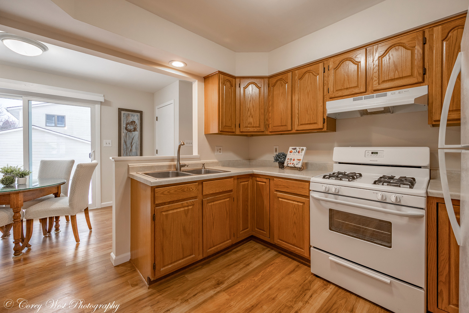 202 Chamberlain Drive DeKalb, IL 60115 - Photo 6 of 28 a kitchen with stainless steel appliances granite countertop a stove a sink dishwasher and white cabinets with wooden floor