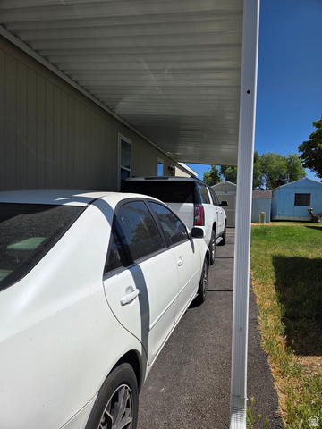 1275 Thrush Road Salt Lake City, UT 84123 - Photo 18 of 20 Carport with a corrugated metal roof providing covered parking, paved driveway, light-colored siding
