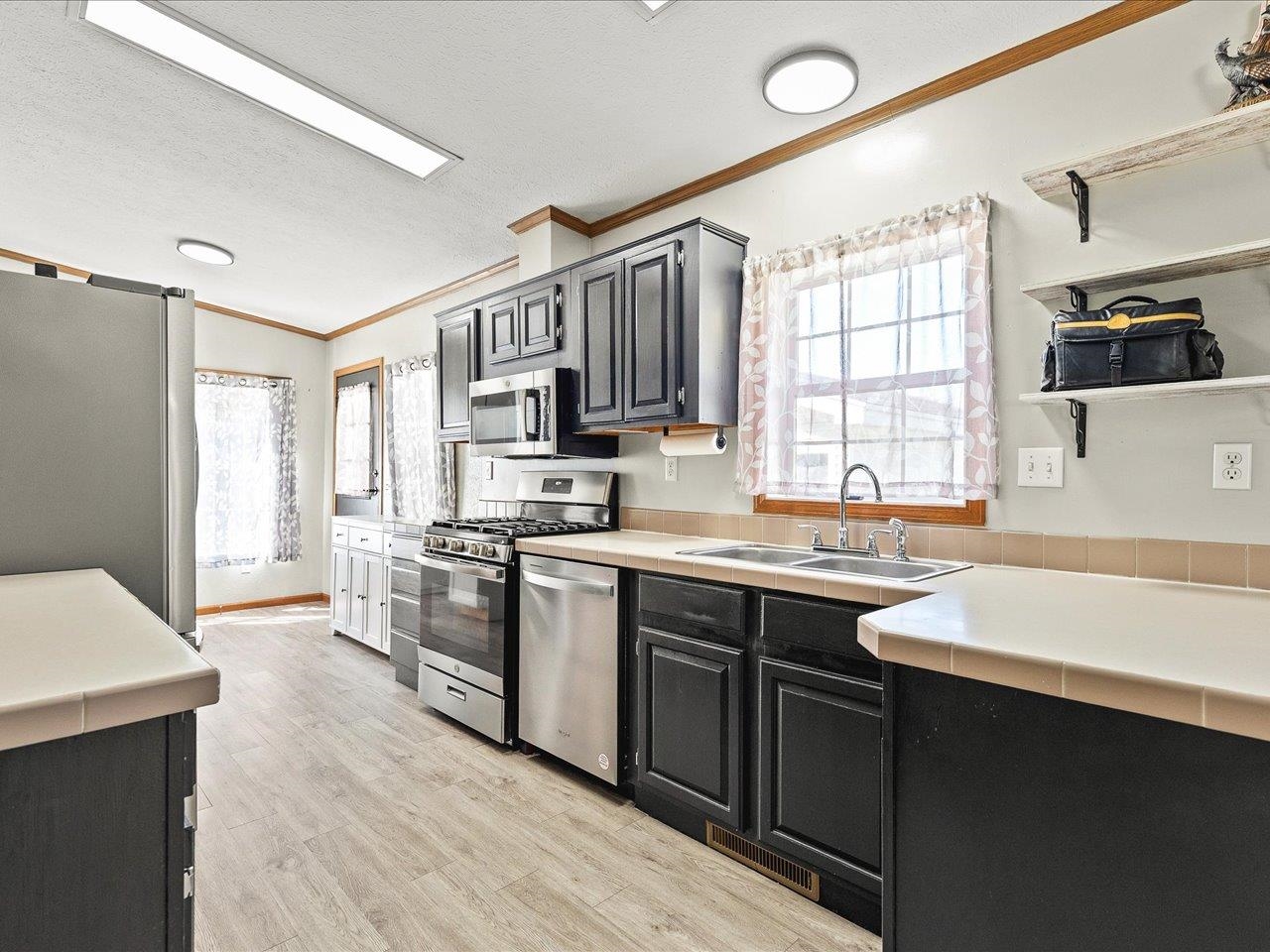 8686 Dutch Elm Court Roscoe, IL 61073 - Photo 11 of 33 a kitchen with stainless steel appliances sink stove refrigerator and a window