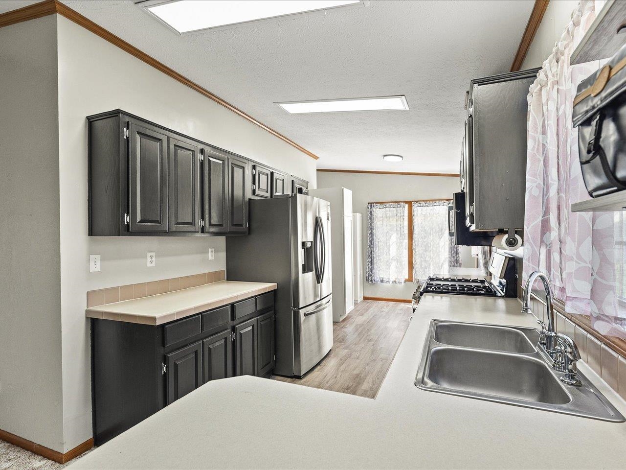 8686 Dutch Elm Court Roscoe, IL 61073 - Photo 12 of 33 a kitchen with stainless steel appliances a sink a stove and a refrigerator