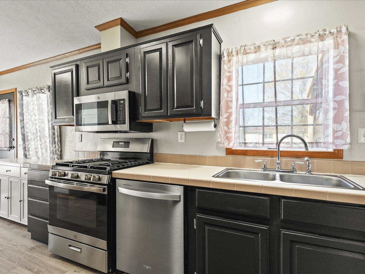 8686 Dutch Elm Court Roscoe, IL 61073 - Photo 13 of 33 a kitchen with stainless steel appliances a stove sink microwave and cabinets